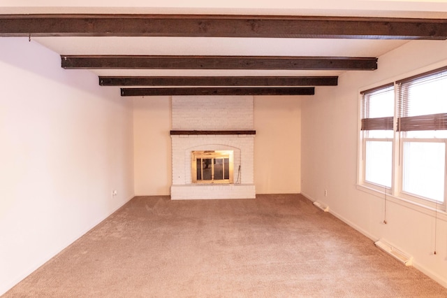 unfurnished living room with beamed ceiling, a fireplace, and carpet flooring