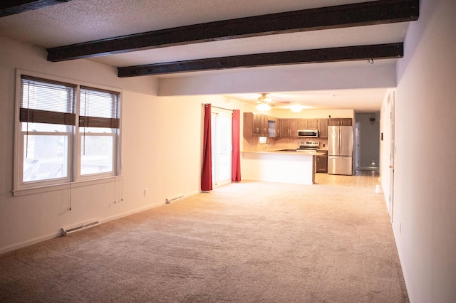 unfurnished living room featuring light carpet, ceiling fan, and beam ceiling