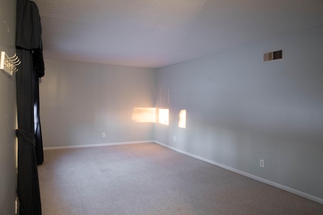 carpeted spare room featuring a textured ceiling