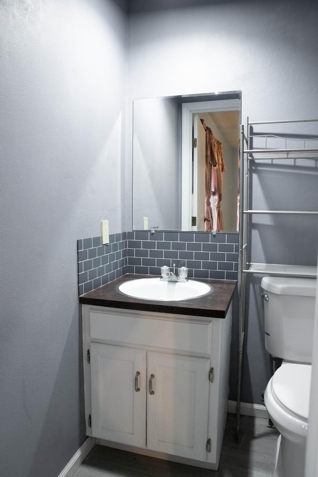 bathroom with backsplash, vanity, and toilet