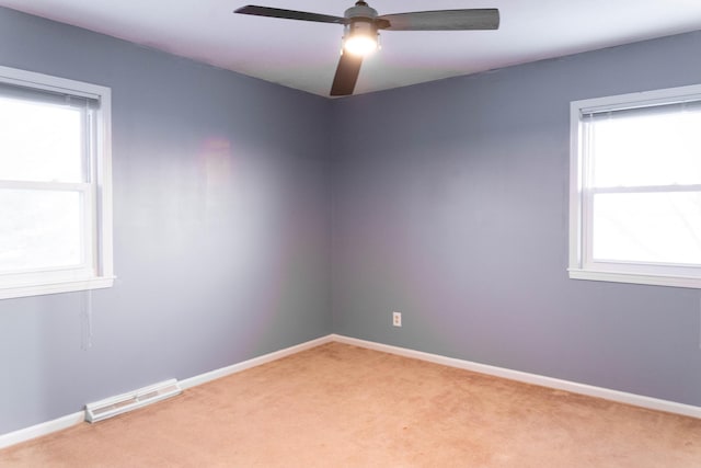 carpeted empty room featuring ceiling fan and plenty of natural light