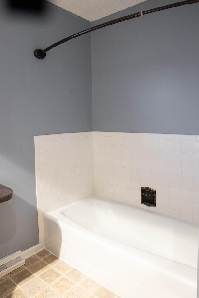 bathroom featuring tile patterned flooring and a tub to relax in