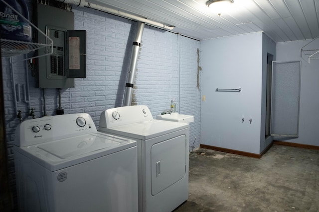 washroom with electric panel, independent washer and dryer, brick wall, and sink