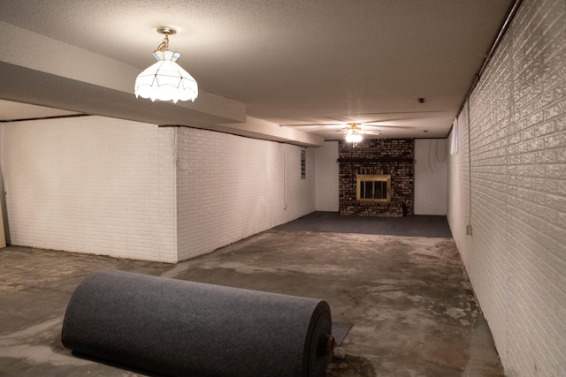 unfurnished living room with ceiling fan, a brick fireplace, and brick wall