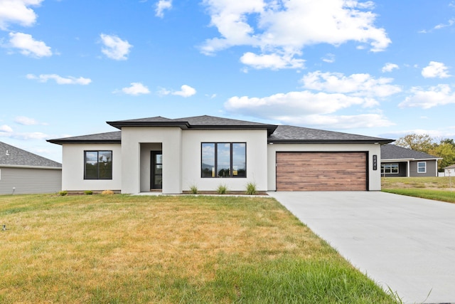 prairie-style house with a garage and a front lawn