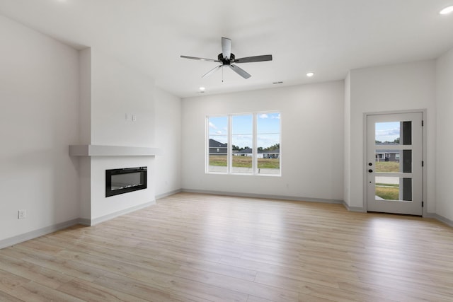 unfurnished living room with light wood-type flooring and ceiling fan