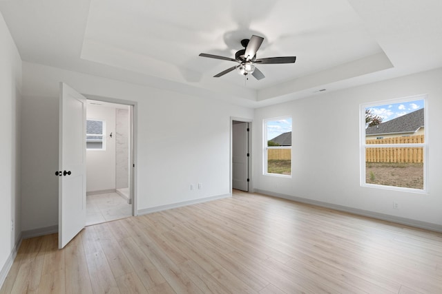 interior space featuring ceiling fan, light hardwood / wood-style floors, and a raised ceiling