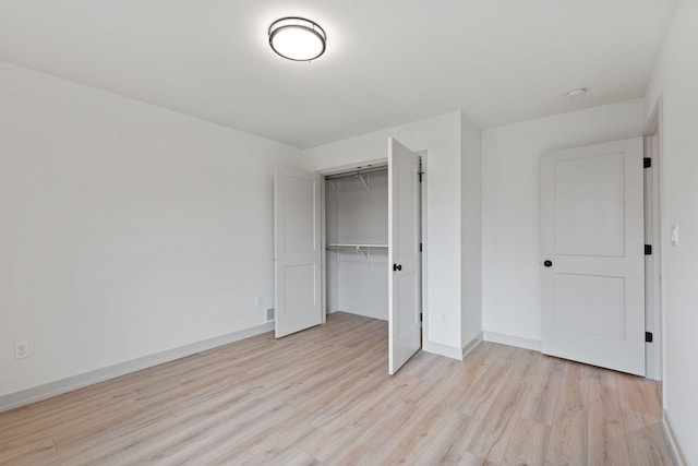 unfurnished bedroom with light hardwood / wood-style floors and a closet