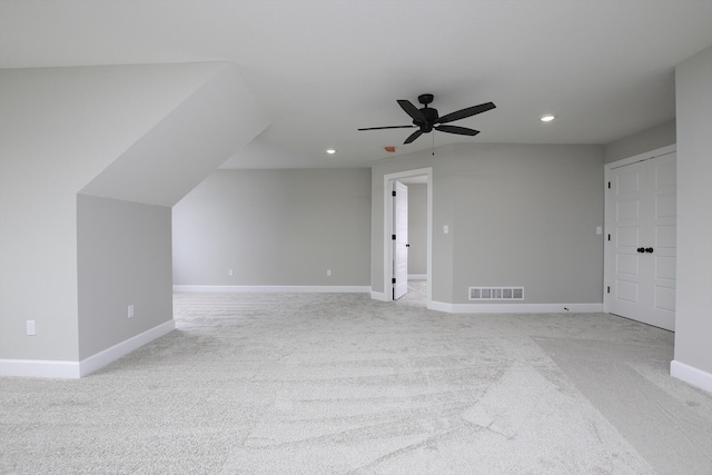 additional living space with ceiling fan and light colored carpet