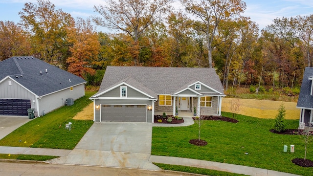 craftsman house featuring a front yard, a garage, central AC unit, and covered porch