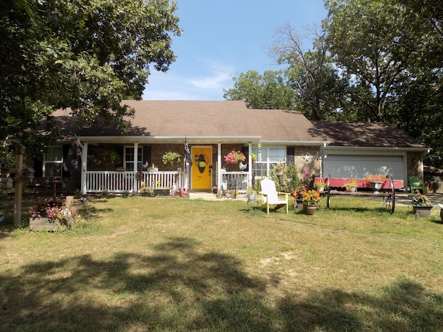 single story home with covered porch, a garage, and a front yard