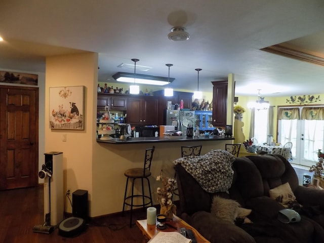 living room featuring crown molding, dark hardwood / wood-style floors, and a notable chandelier