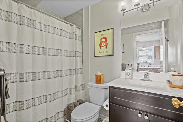 bathroom featuring toilet, a shower with shower curtain, and vanity