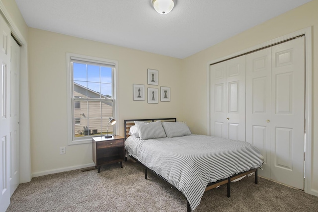 bedroom featuring carpet and multiple closets