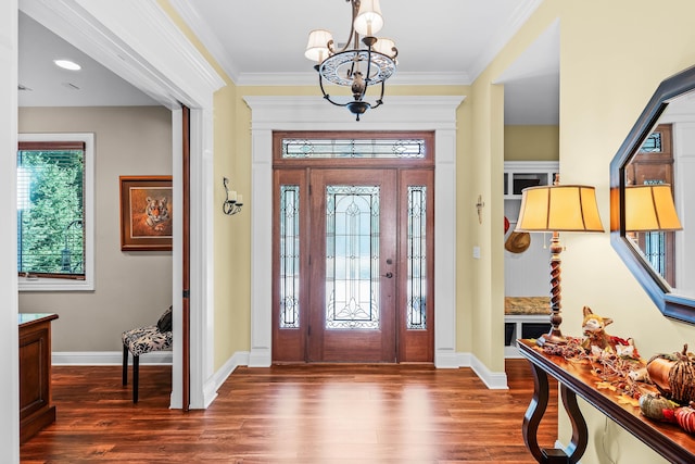 entrance foyer featuring dark hardwood / wood-style floors, an inviting chandelier, and crown molding