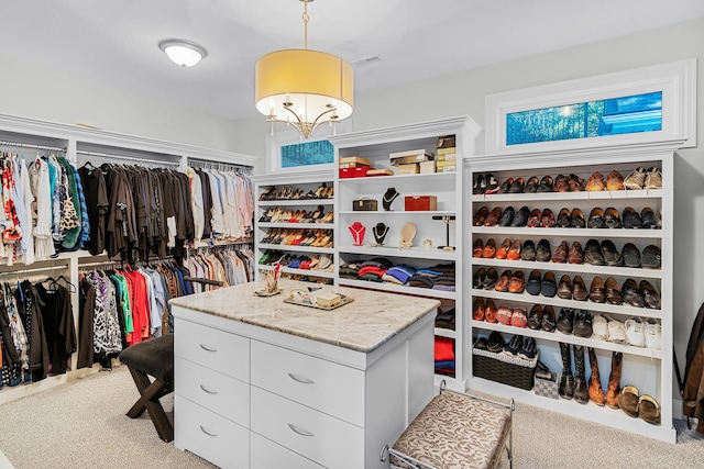 walk in closet featuring light colored carpet