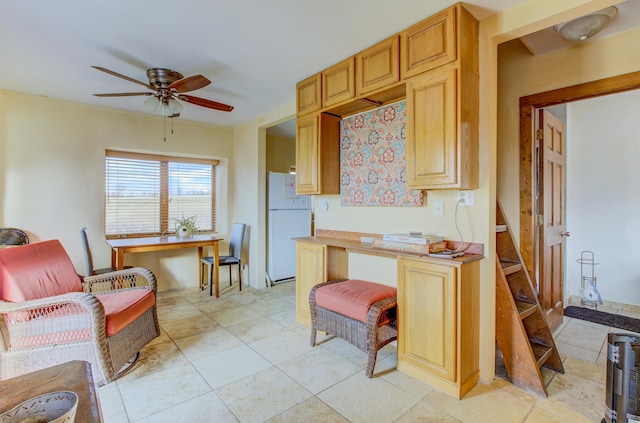 kitchen with ceiling fan, white fridge, and light brown cabinetry