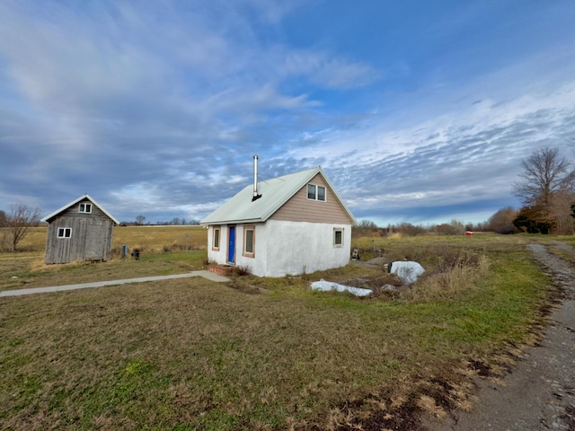 view of home's exterior with a shed and a yard