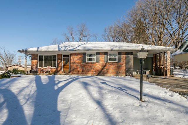 snow covered rear of property featuring a carport