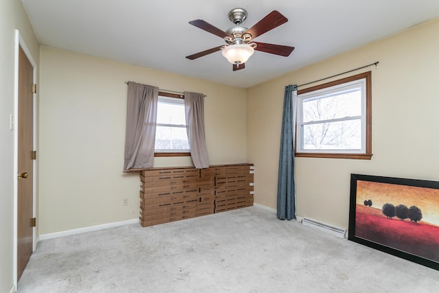 unfurnished bedroom with ceiling fan, light colored carpet, and a baseboard heating unit