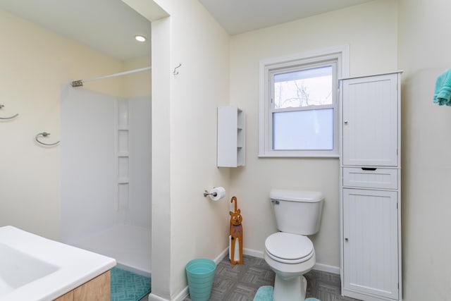 bathroom with a shower, vanity, and toilet