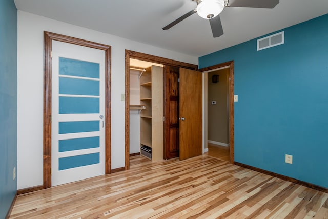 unfurnished bedroom featuring baseboard heating, ceiling fan, a closet, and light hardwood / wood-style flooring