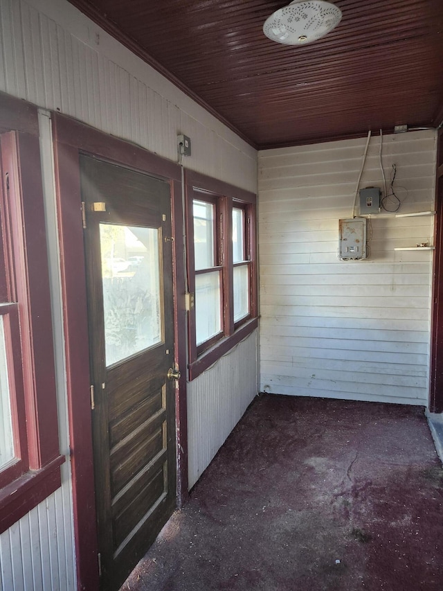 doorway with wood walls and wooden ceiling