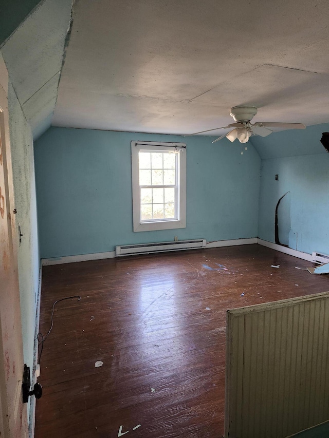 additional living space featuring ceiling fan, dark wood-type flooring, vaulted ceiling, and a baseboard heating unit