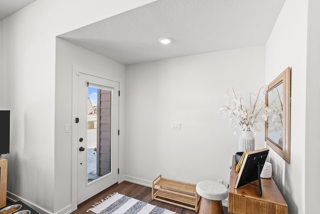 entrance foyer with a textured ceiling and dark hardwood / wood-style flooring