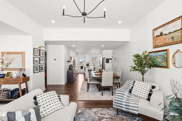 living room with dark wood-type flooring and an inviting chandelier