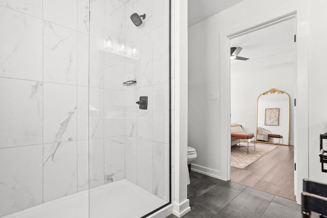 bathroom with ceiling fan, tile patterned floors, a tile shower, and toilet