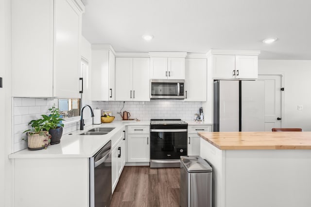 kitchen with backsplash, white cabinetry, sink, and stainless steel appliances