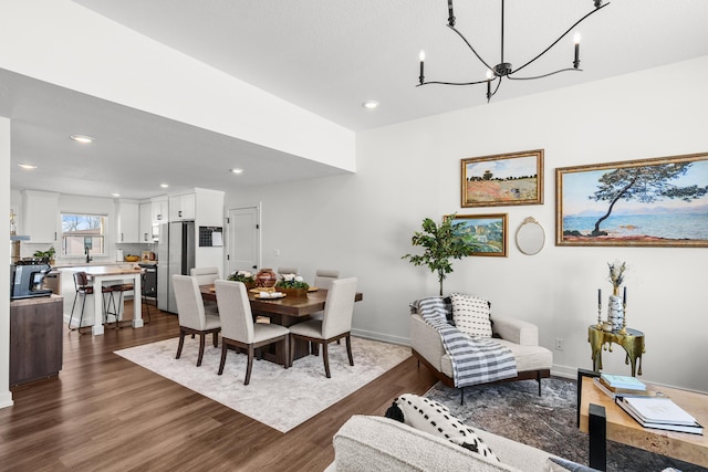 dining room with dark hardwood / wood-style floors and an inviting chandelier