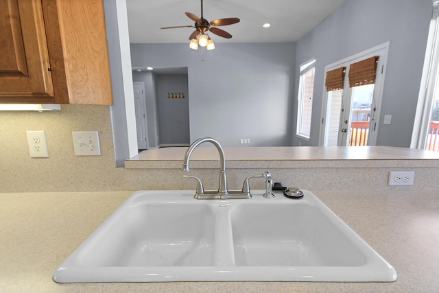 kitchen featuring sink, ceiling fan, backsplash, and kitchen peninsula