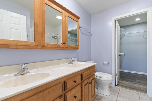 bathroom with tile patterned flooring, vanity, and toilet