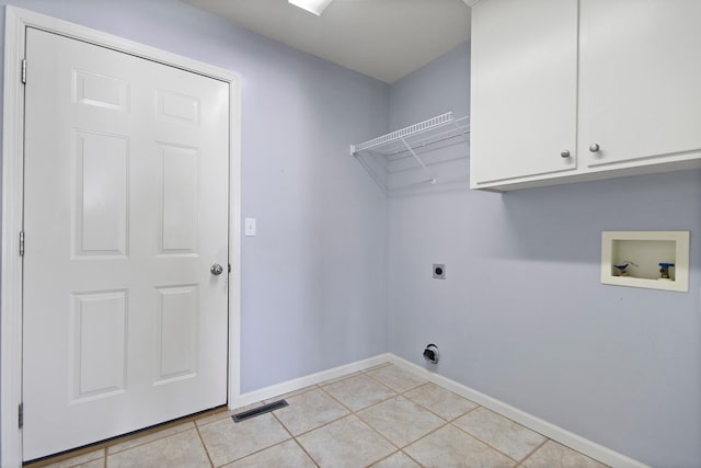 washroom with washer hookup, cabinets, hookup for an electric dryer, and light tile patterned flooring