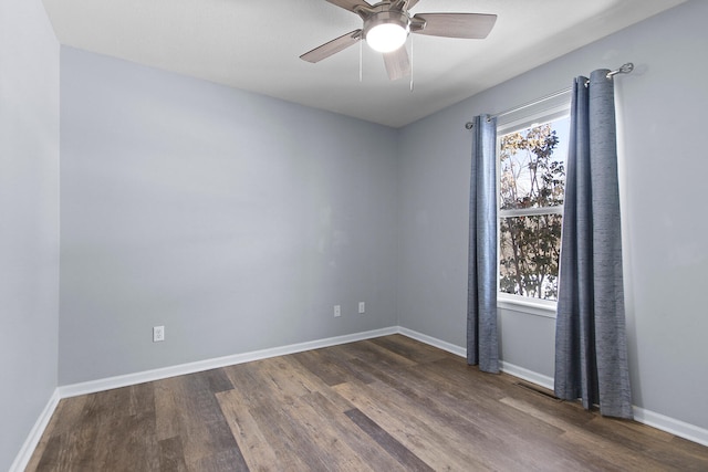 empty room with ceiling fan and dark hardwood / wood-style floors