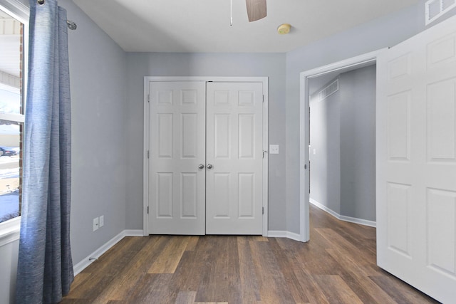 unfurnished bedroom with ceiling fan, a closet, and dark hardwood / wood-style floors