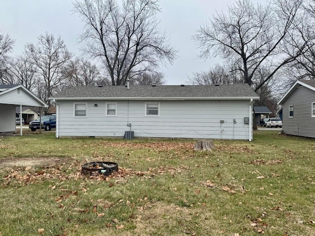 rear view of house with crawl space, a lawn, a fire pit, and central air condition unit