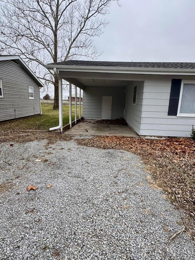 view of parking with driveway and an attached carport