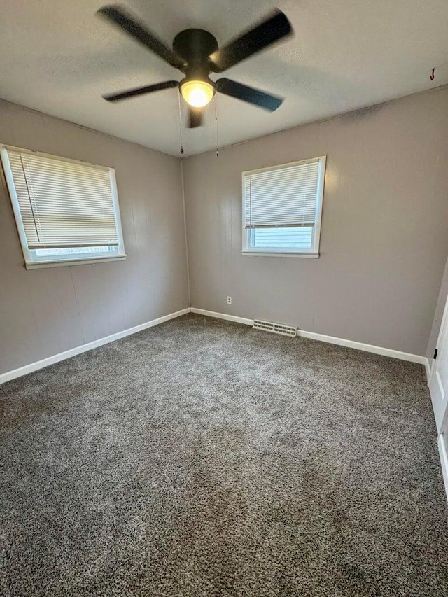 carpeted spare room featuring baseboards, visible vents, ceiling fan, and a textured ceiling