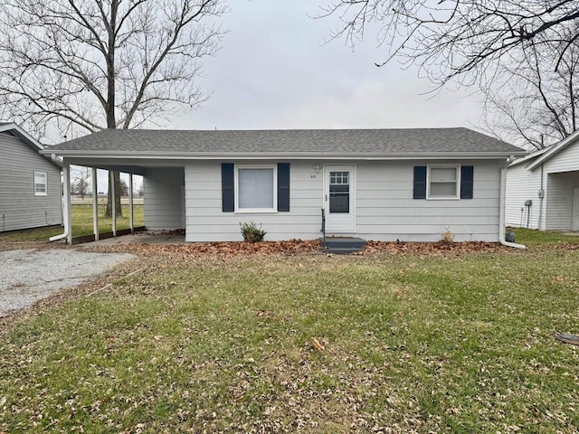 view of front of house with a carport, a shingled roof, gravel driveway, and a front yard