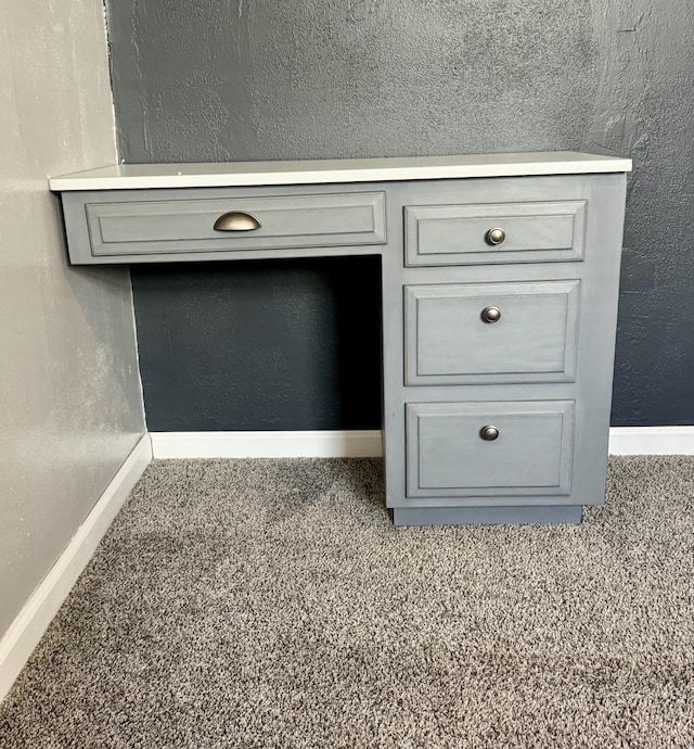 room details featuring a textured wall, carpet flooring, and baseboards