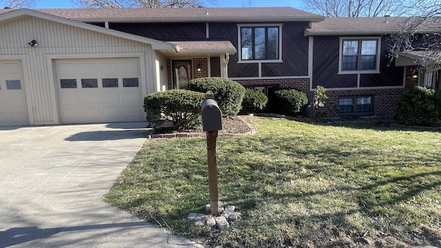 tri-level home with a front yard, an attached garage, brick siding, and driveway