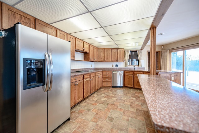 kitchen featuring stainless steel appliances, backsplash, and sink