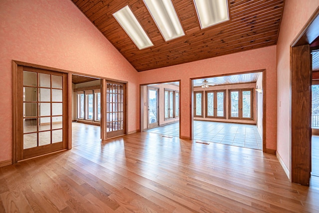 spare room with high vaulted ceiling, light hardwood / wood-style floors, plenty of natural light, and ceiling fan