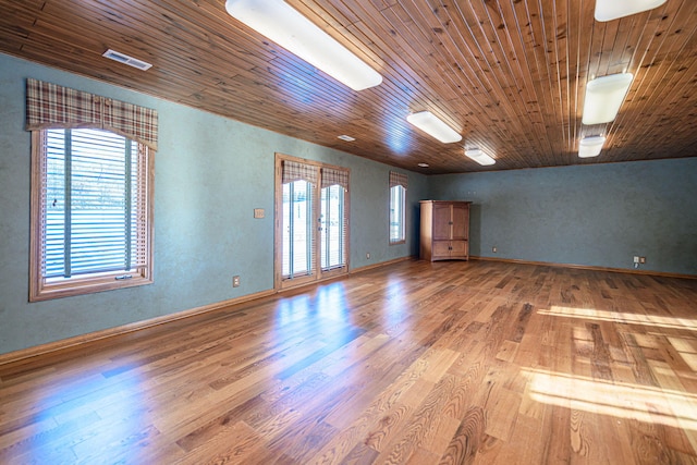 empty room featuring wooden ceiling and light hardwood / wood-style floors