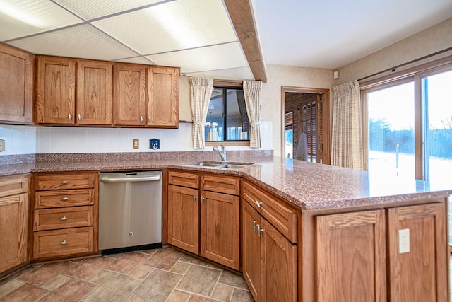 kitchen featuring light stone countertops, stainless steel dishwasher, kitchen peninsula, and sink