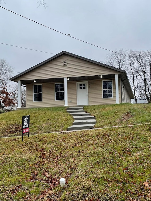 ranch-style home featuring a porch and a front lawn