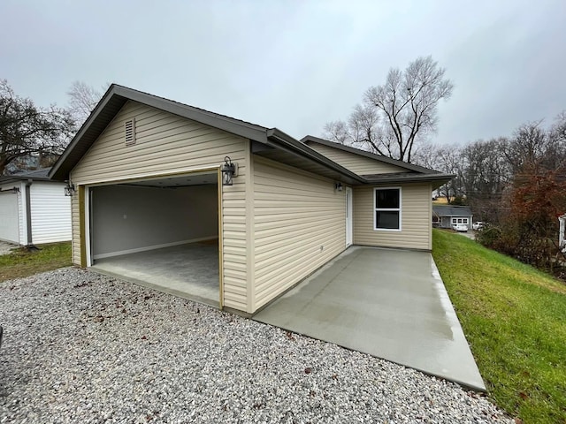 view of side of home featuring a garage and a lawn